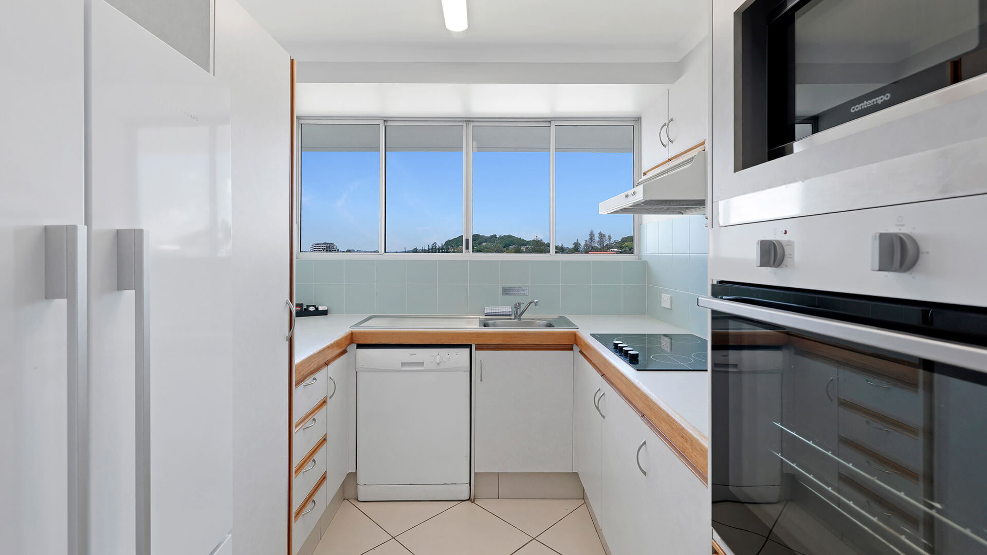 Fully equipped kitchen in the Standard 2 Bedroom Centre Front Apartment at ULTIQA Points North, with window views.