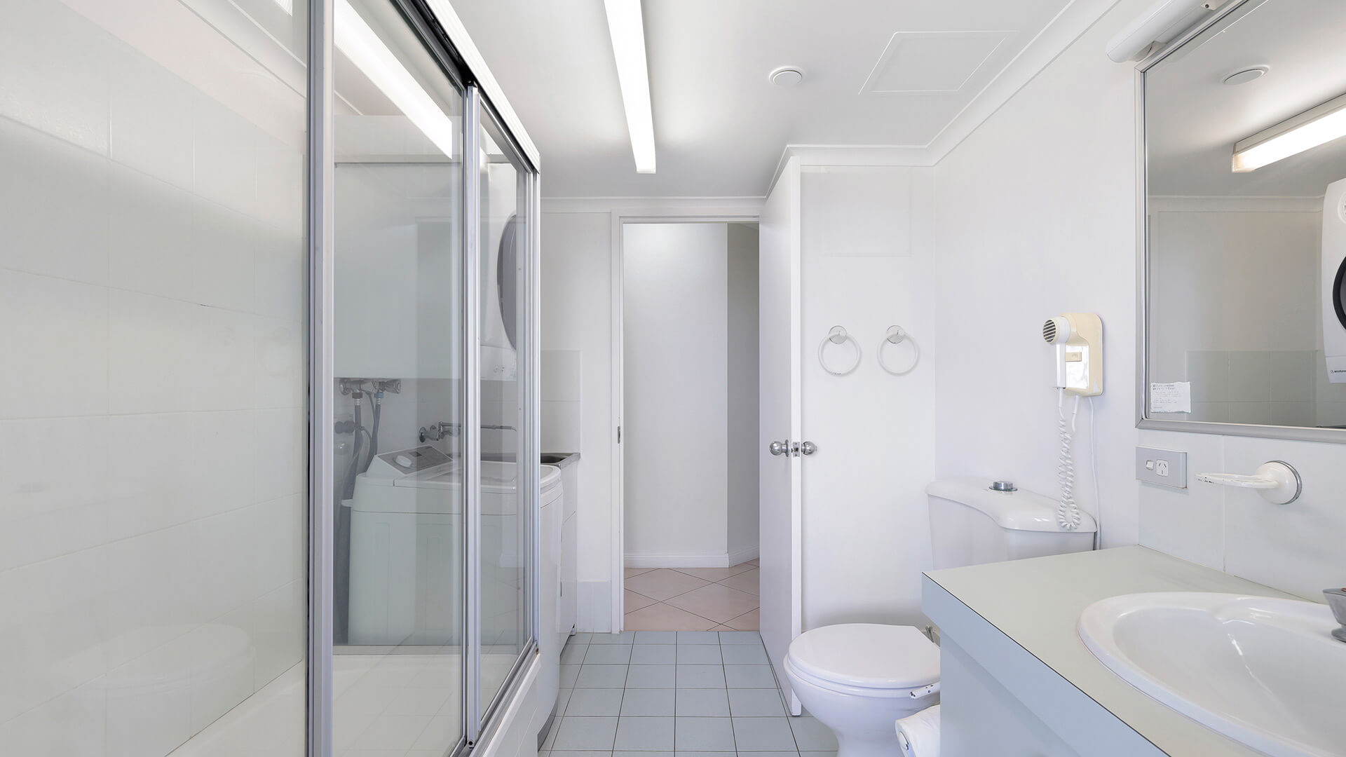 Bathroom and laundry area in the Standard 2 Bedroom Ocean View Apartment at ULTIQA Points North, featuring a shower and vanity.