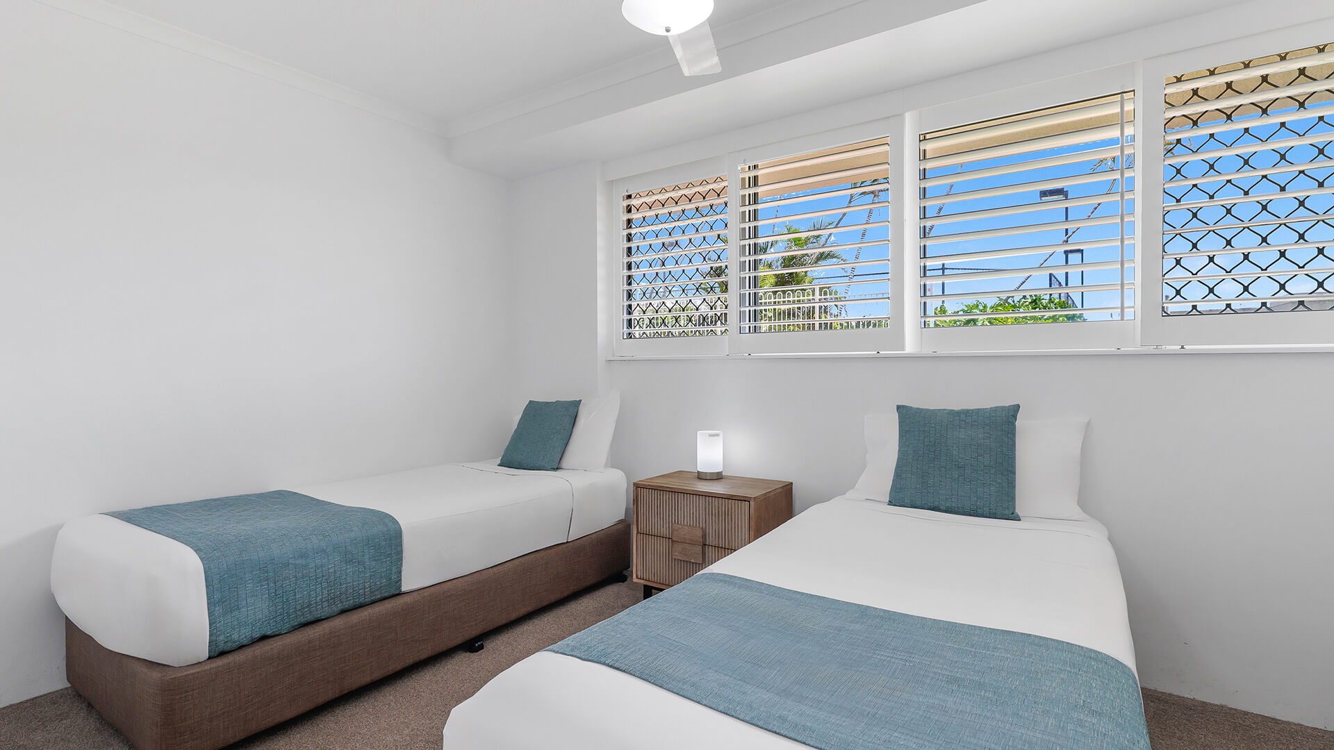 Twin bedroom in the Superior 2 Bedroom Courtyard Apartment at ULTIQA Points North, with natural light and garden outlook.