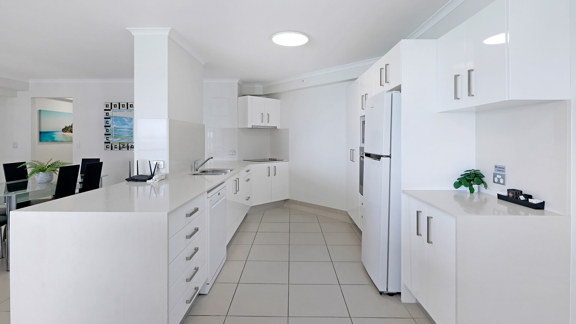 Dining area of the 2 Bedroom Superior Ocean View Apartment with a glass table, black chairs, and open layout to the lounge and balcony.