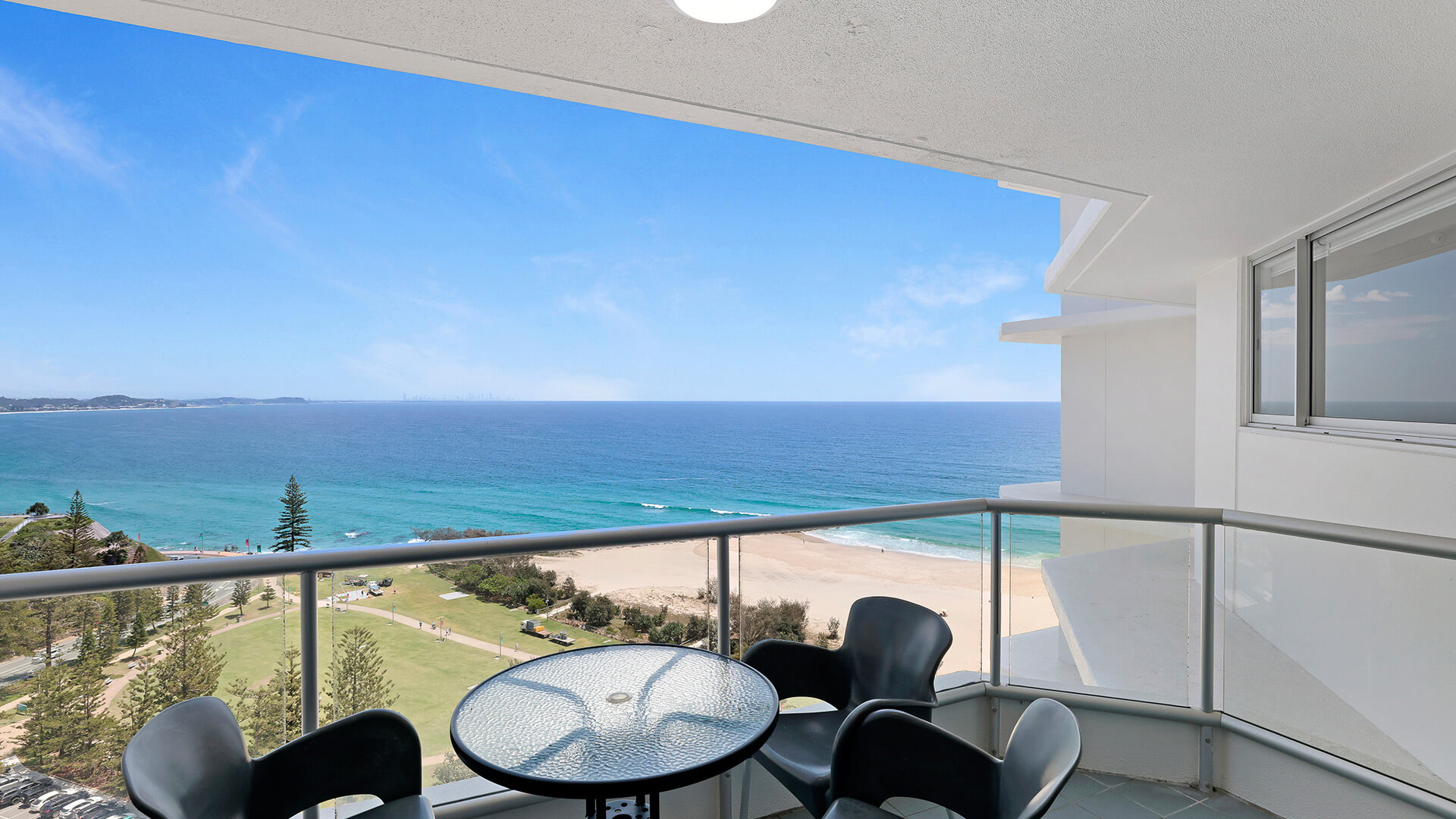 Private balcony of the 2 Bedroom Superior Ocean View Apartment with outdoor seating and panoramic views of the ocean and beach.