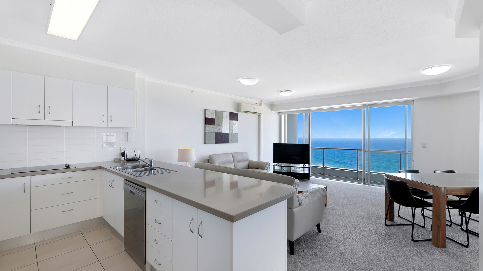 Open-plan kitchen, living and dining area with ocean views in the Deluxe 2 Bedroom Centre Front Apartment at ULTIQA Points North.