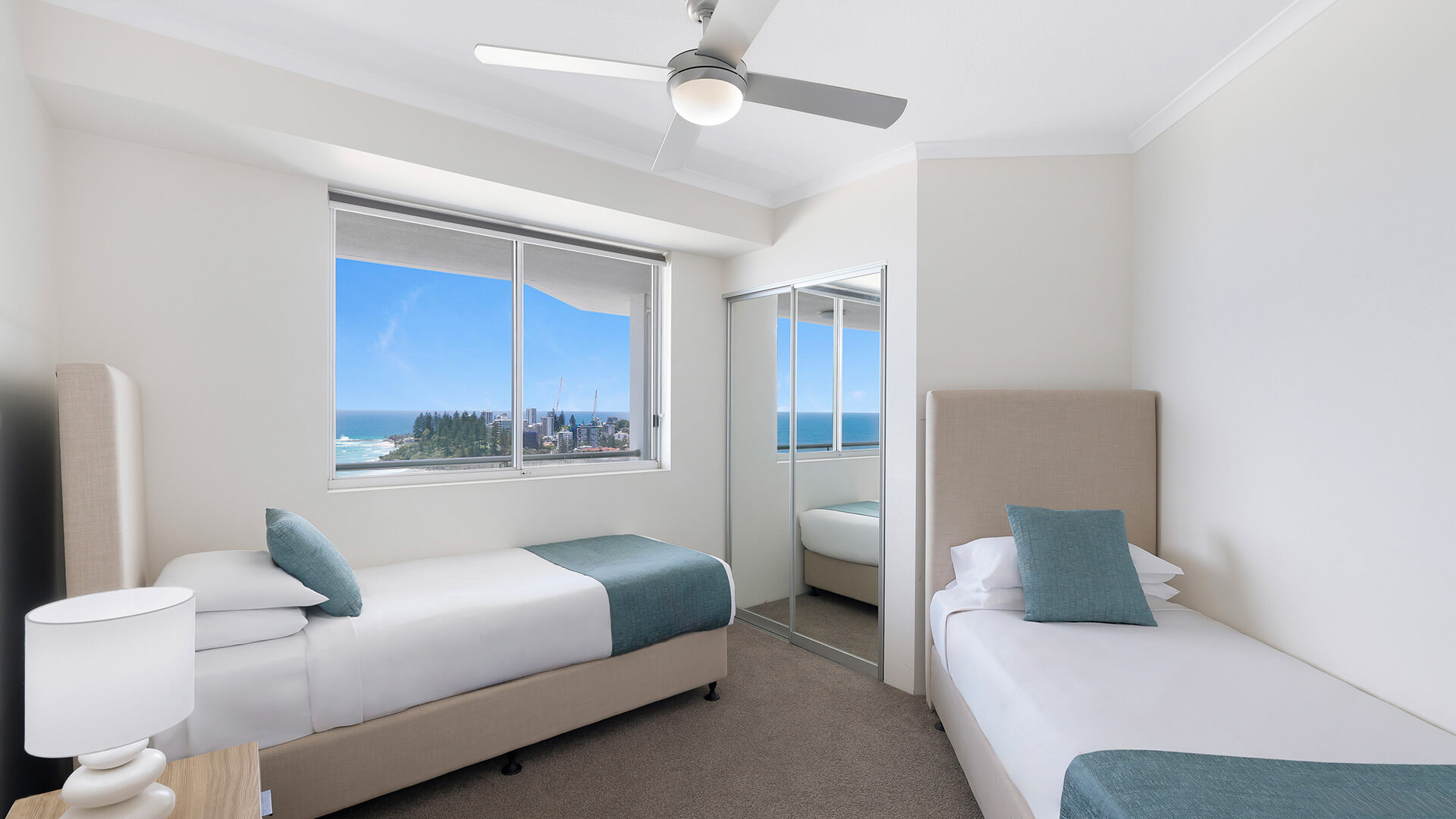 Second bedroom with twin beds and ocean views in the Deluxe 2 Bedroom Centre Front Apartment at ULTIQA Points North.