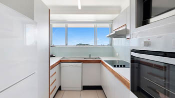 Fully equipped kitchen in the Standard 2 Bedroom Ocean View Apartment at ULTIQA Points North, with window views.