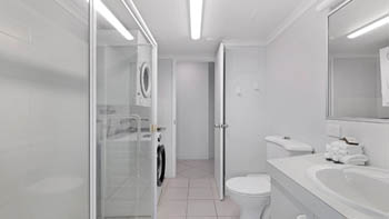 Second bathroom in the Standard 2 Bedroom Centre Front Apartment at ULTIQA Points North, featuring a shower and laundry facilities.