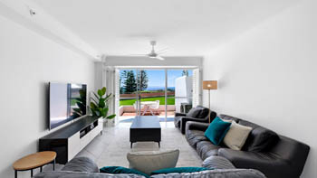 Living area in the Superior 2 Bedroom Courtyard Apartment at ULTIQA Points North, opening onto a private courtyard with ocean glimpses.