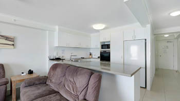 Kitchen and living area in the Deluxe 2 Bedroom Centre Front Apartment at ULTIQA Points North.