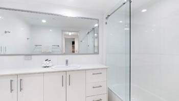 Bathroom with shower over bath in the Deluxe 2 Bedroom Centre Front Apartment at ULTIQA Points North.