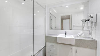 Bright modern bathroom with shower-over-bath in the Deluxe 2 Bedroom Centre Front Apartment at ULTIQA Points North.