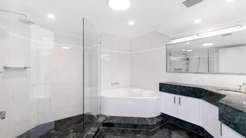 Spacious bathroom in the 4 Bedroom Oceanfront Penthouse at ULTIQA Points North with spa bath, walk-in shower, and marble flooring.
