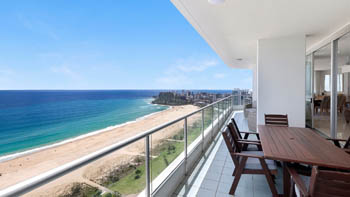 Oceanfront balcony of the 4 Bedroom Oceanfront Penthouse at ULTIQA Points North with outdoor dining and beach views.