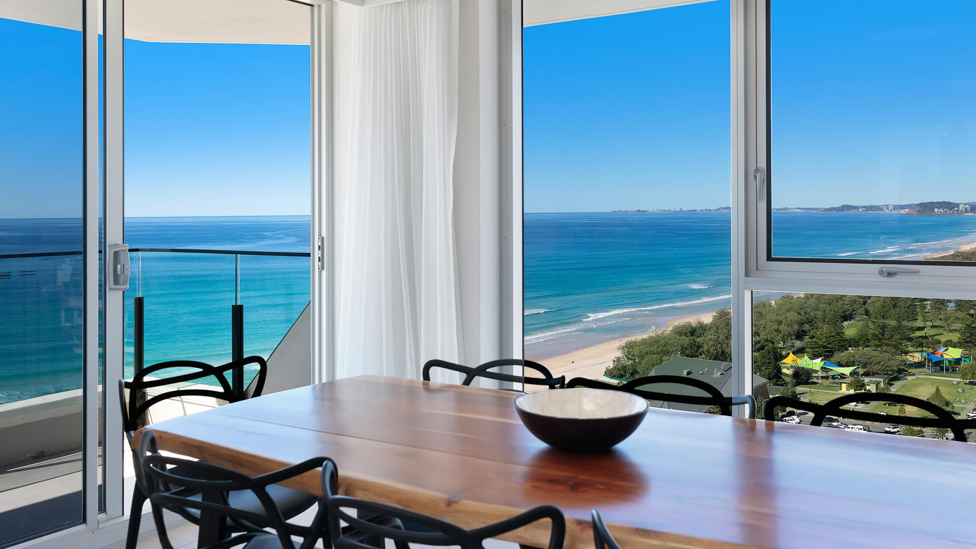 Dining table with ocean and coastline views in ULTIQA Beach Haven apartment, Surfers Paradise