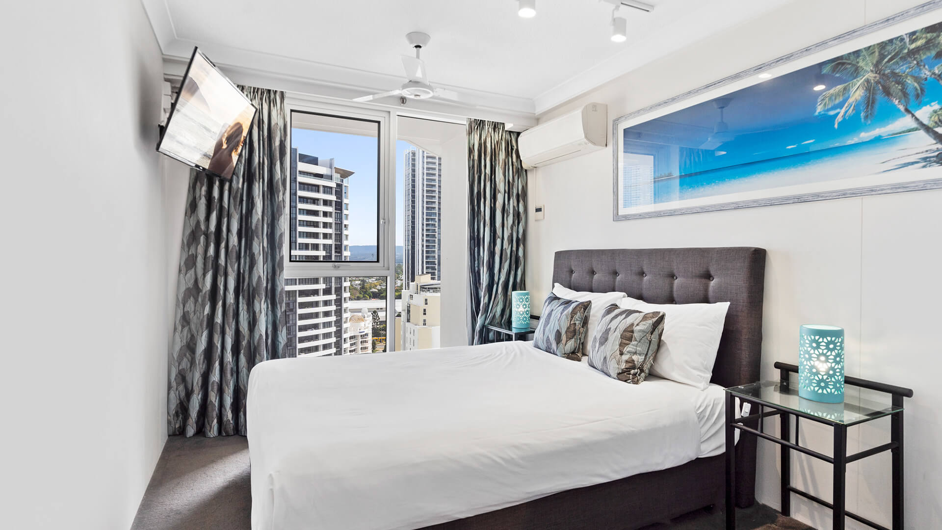 Second bedroom with a king bed and a TV in the corner at ULTIQA Beach Haven.