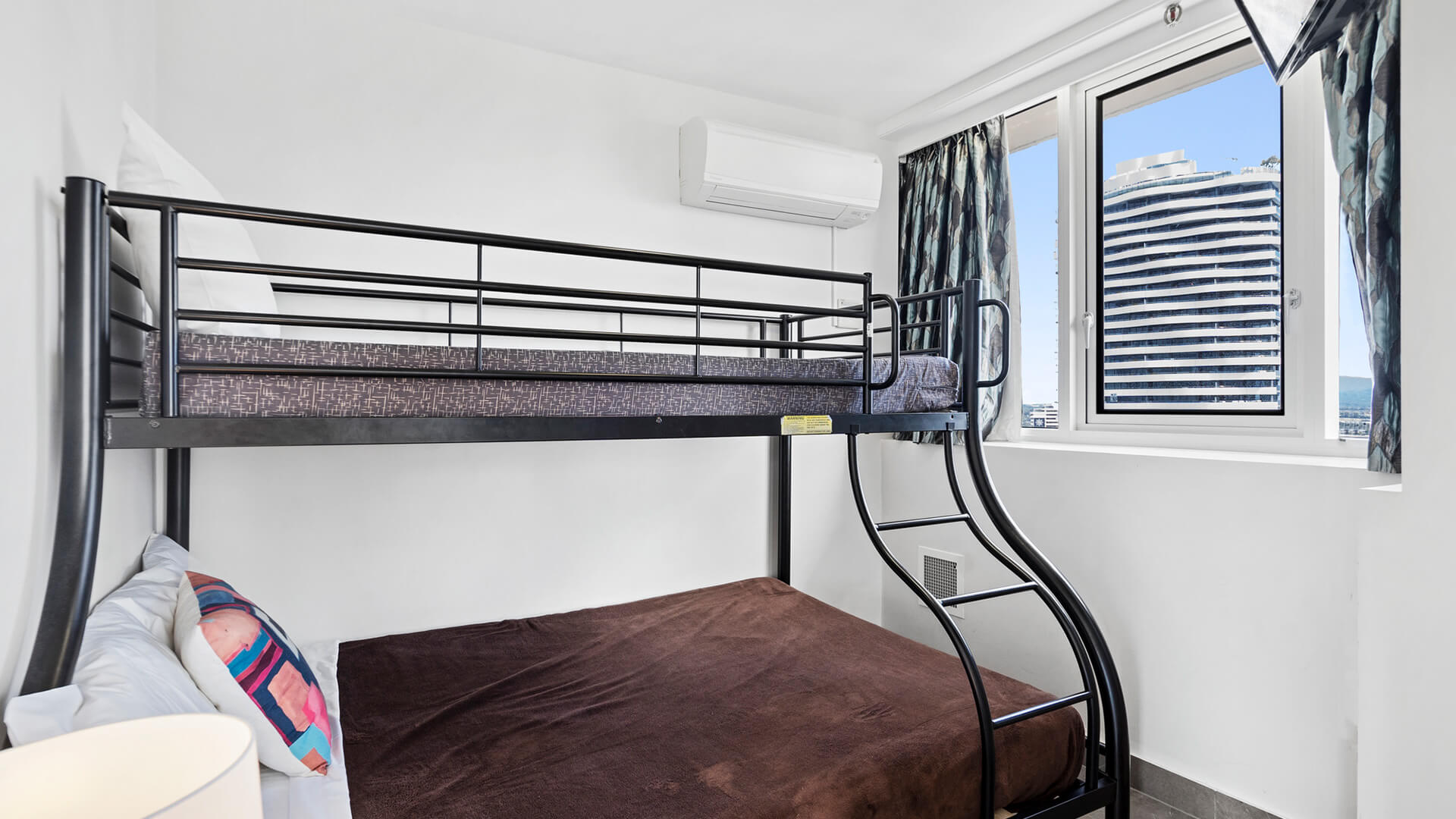 Third bedroom with white walls, bunk beds and a window at ULTIQA Beach Haven.