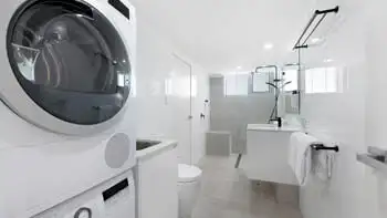 Bathroom featuring a walk-in shower and dual vanity.