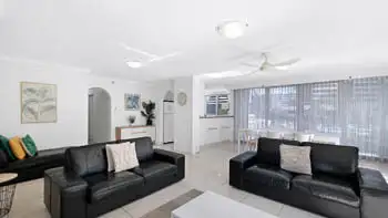 Open living space with black leather couches and natural light in the 2 Bedroom Apartment at ULTIQA Beach Haven on Broadbeach.