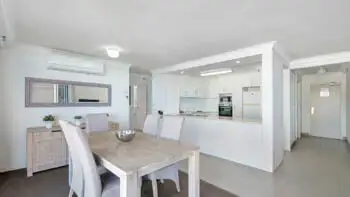 Open-plan kitchen and dining area in the 2 Bedroom Ocean View Apartment at ULTIQA Beach Haven on Broadbeach with modern appliances and coastal-style furnishings.