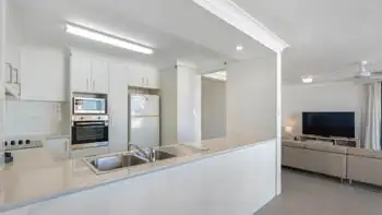 Kitchen in the 2 Bedroom Ocean View Apartment at ULTIQA Beach Haven on Broadbeach with double sink, built-in oven, and open layout to living area.