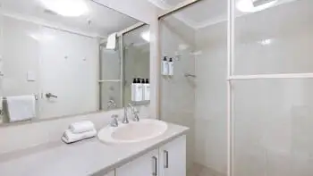 Bathroom in the Standard 2 Bedroom Ocean View Apartment at ULTIQA Beach Haven on Broadbeach featuring a walk-in shower and vanity.