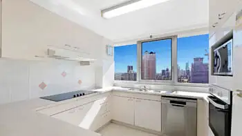 Fully equipped kitchen with city skyline views in the Standard 2 Bedroom Ocean View Apartment at ULTIQA Beach Haven on Broadbeach.