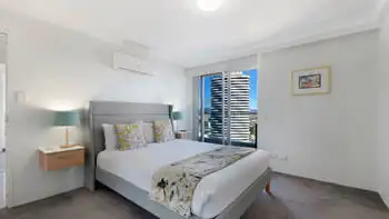Main bedroom featuring a king bed, air-conditioning, private balcony access, and views over Broadbeach.