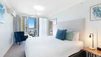 Main bedroom with plush bedding and city views at ULTIQA Beach Haven on Broadbeach, Surfers Paradise apartment.