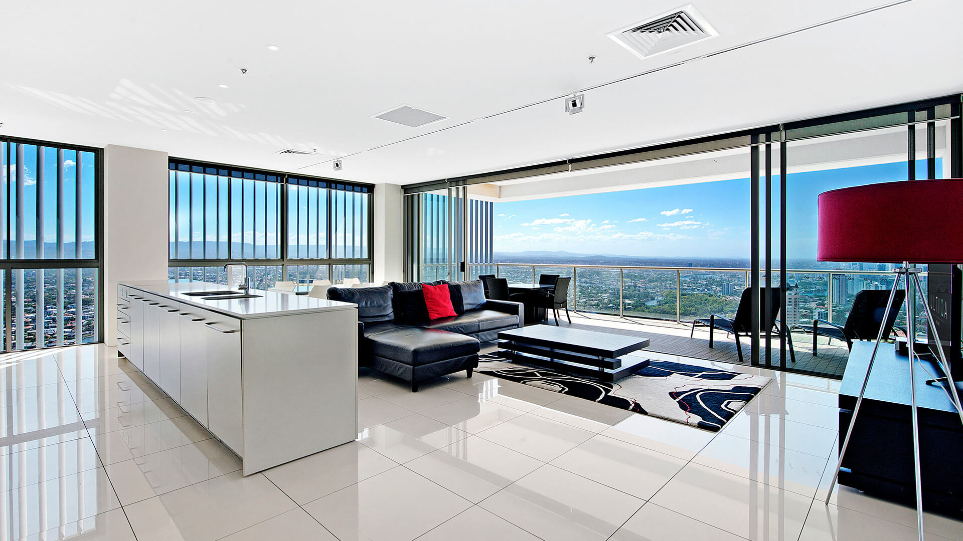 Spacious open-plan living, dining, and kitchen with sweeping hinterland and ocean views from the 2 Bedroom Gold Coast View Suite at ULTIQA Air on Broadbeach.