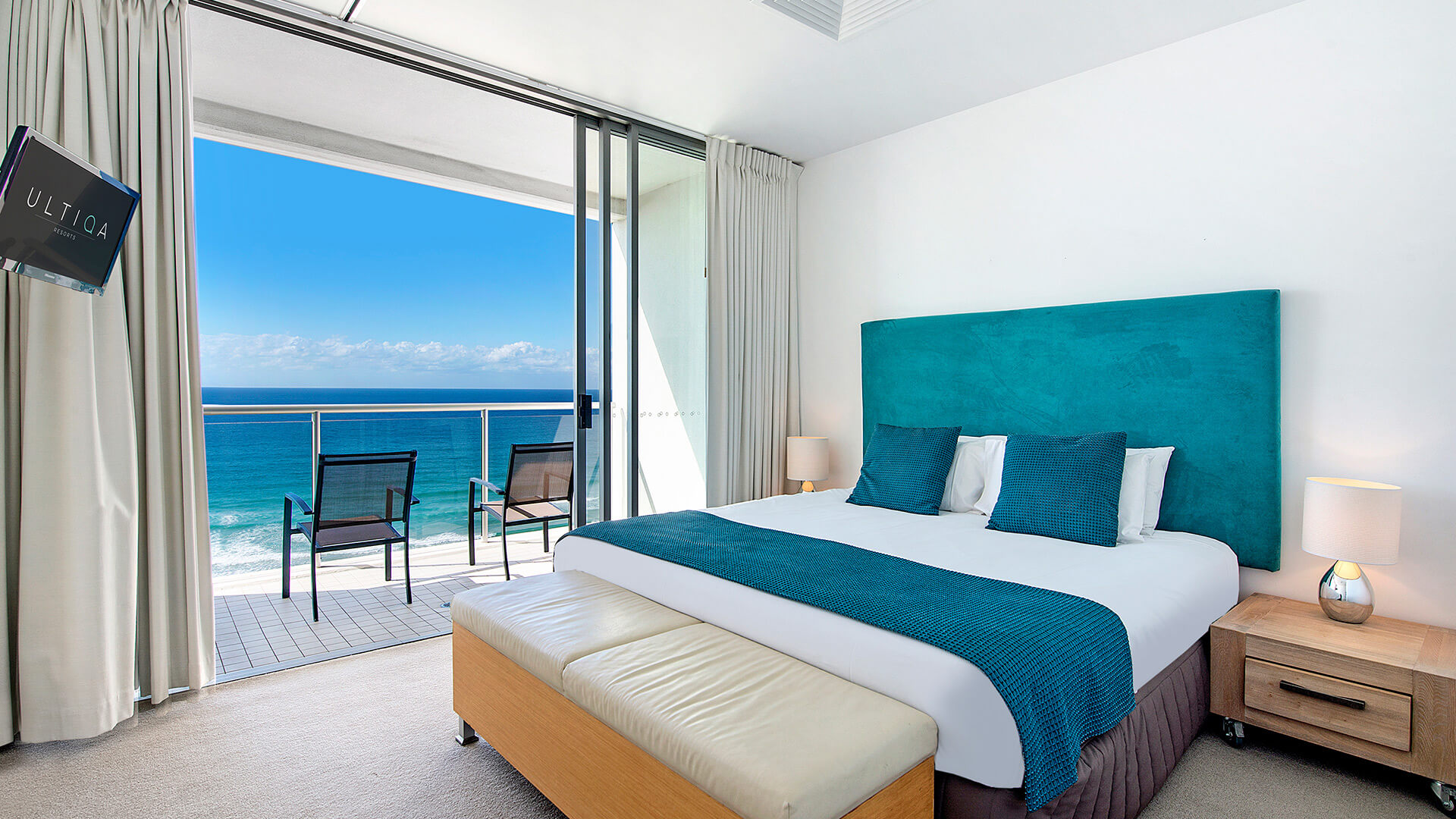 Master bedroom with king bed and private balcony offering panoramic ocean views in 2 Bedroom Ocean View Apartment at ULTIQA Air on Broadbeach.