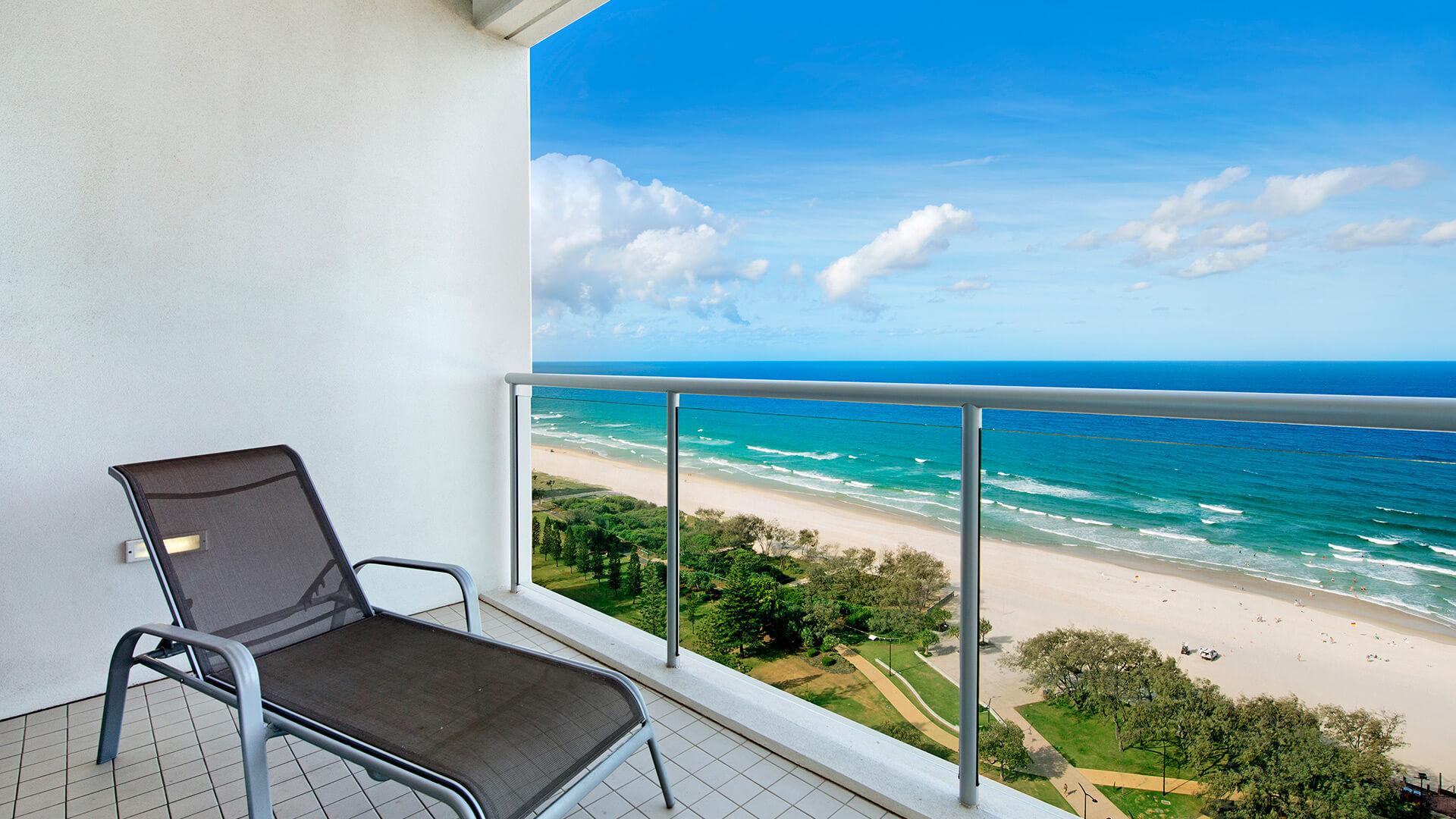 Balcony with sun lounger and sweeping ocean and park views – 2 Bedroom Ocean View Suite at ULTIQA Air on Broadbeach.