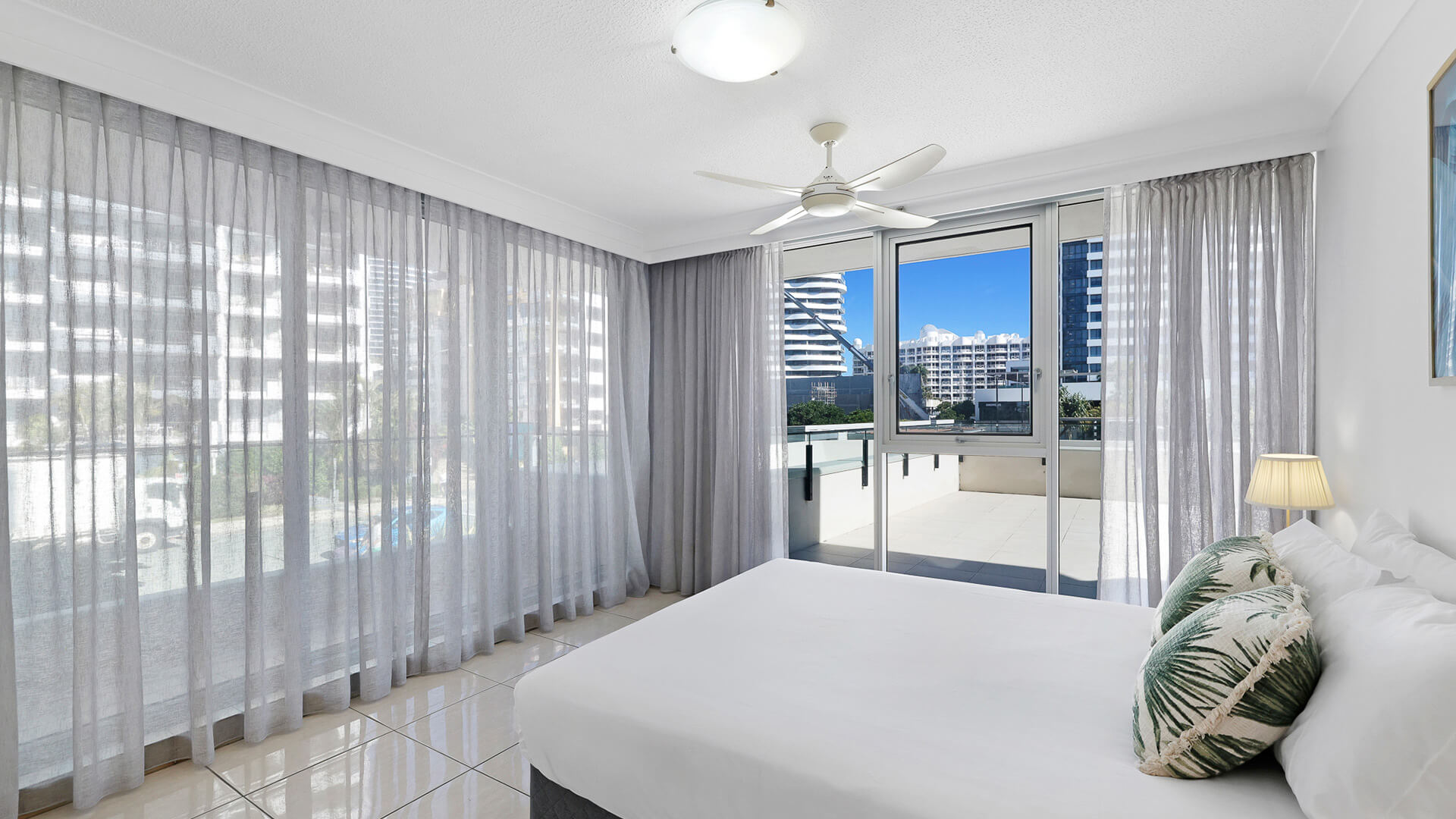 Bedroom with king bed, ceiling fan and balcony access in the 2 Bedroom Apartment at ULTIQA Beach Haven.