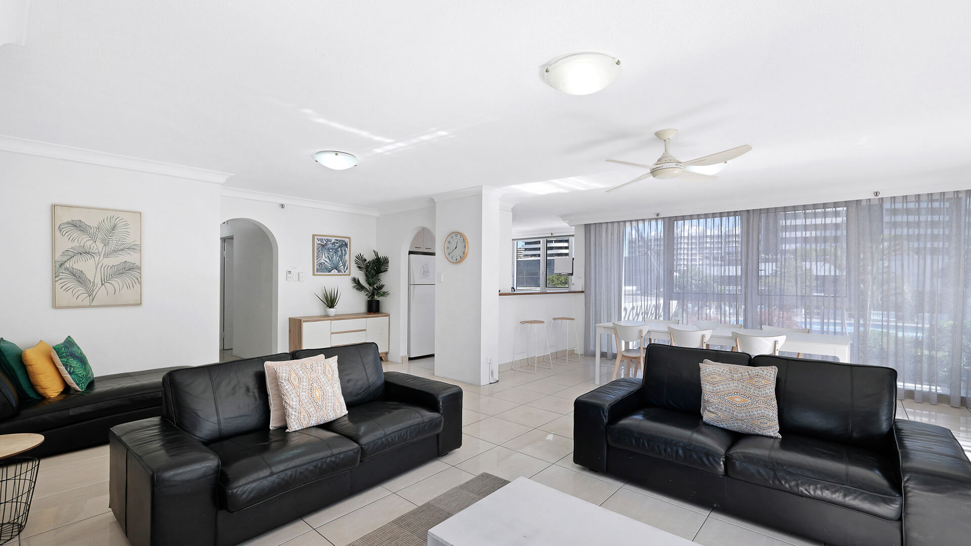 Open living space with black leather couches and natural light in the 2 Bedroom Apartment at ULTIQA Beach Haven.