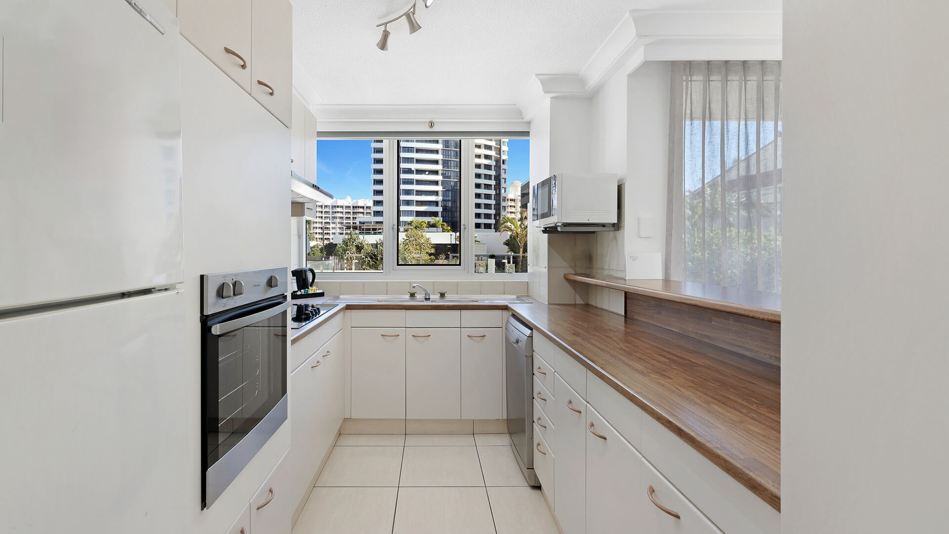 Fully equipped kitchen with modern appliances and city views in the 2 Bedroom Apartment at ULTIQA Beach Haven.