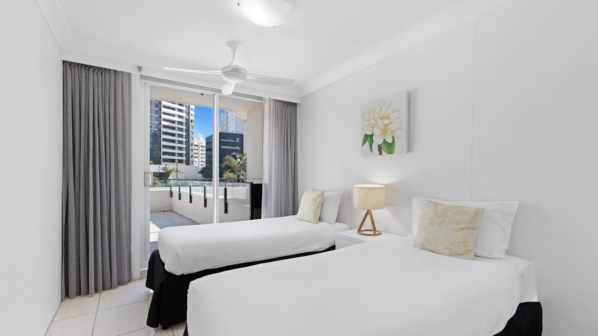 Second bedroom with two single beds and balcony access in the 2 Bedroom Apartment at ULTIQA Beach Haven.