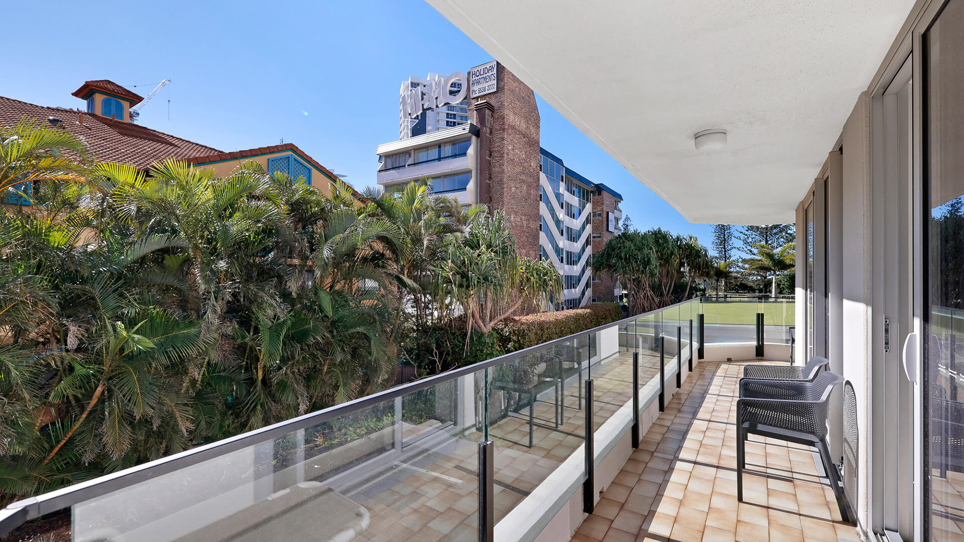 Private balcony with outdoor seating and leafy garden views in the 2 Bedroom Apartment at ULTIQA Beach Haven.