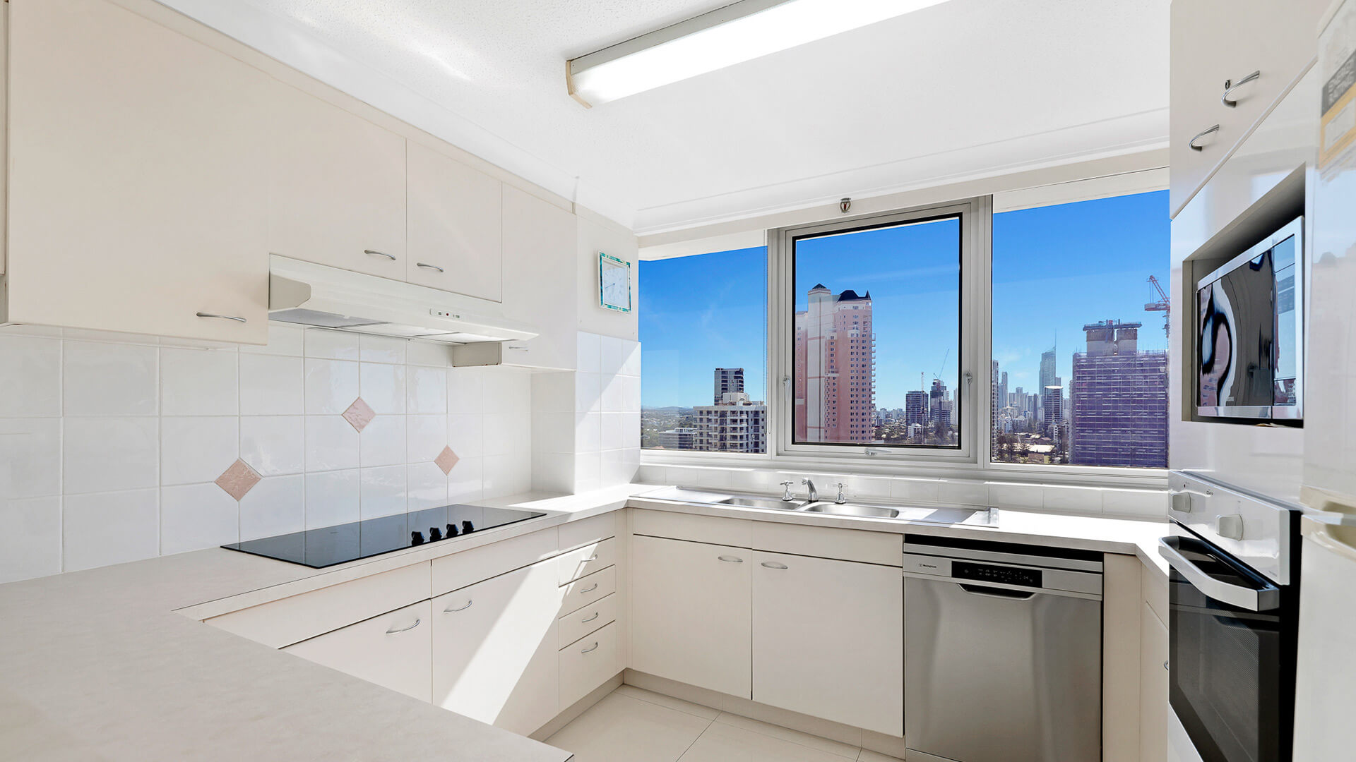 Fully equipped kitchen with city skyline views in the Standard 2 Bedroom Ocean View Apartment at ULTIQA Beach Haven.