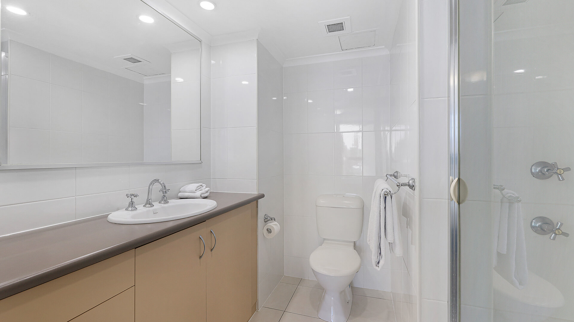 Main bathroom with walk-in shower, vanity, and toilet in the Standard 2 Bedroom Ocean View Apartment at ULTIQA Beach Haven.