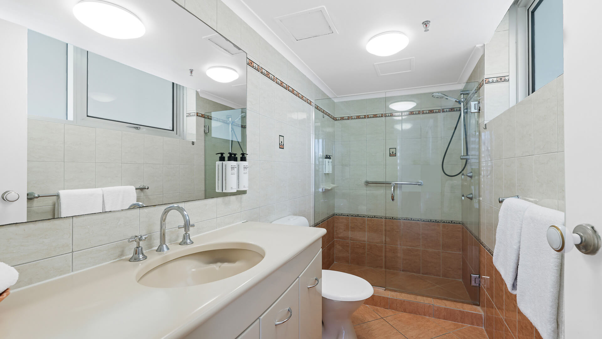 Bathroom in the Standard 2 Bedroom Ocean View Apartment at ULTIQA Beach Haven, featuring a spacious walk-in shower, vanity, and large mirror.