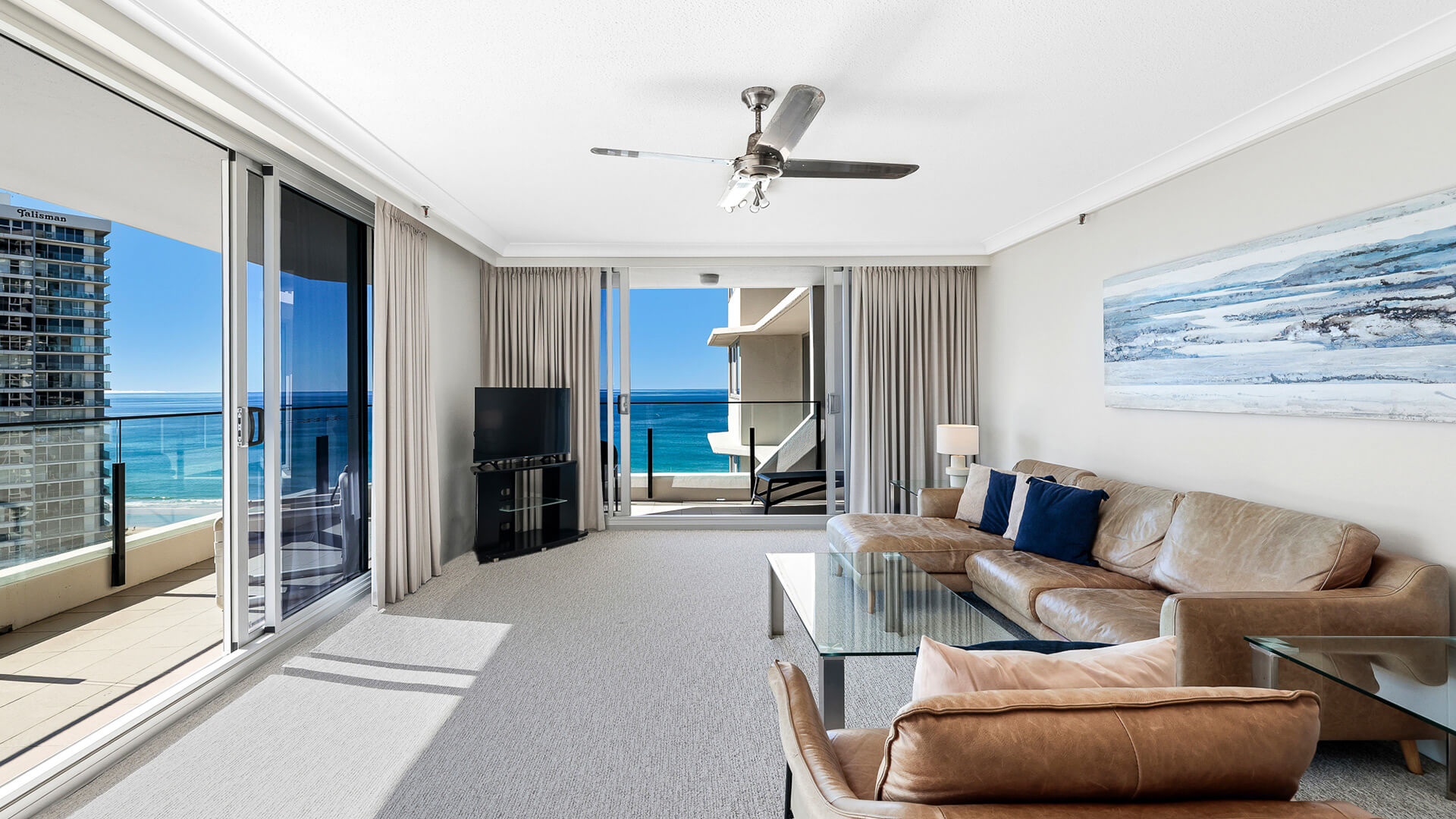 Living room in the 2 Bedroom Ocean View Apartment at ULTIQA Beach Haven with leather seating and panoramic ocean views.