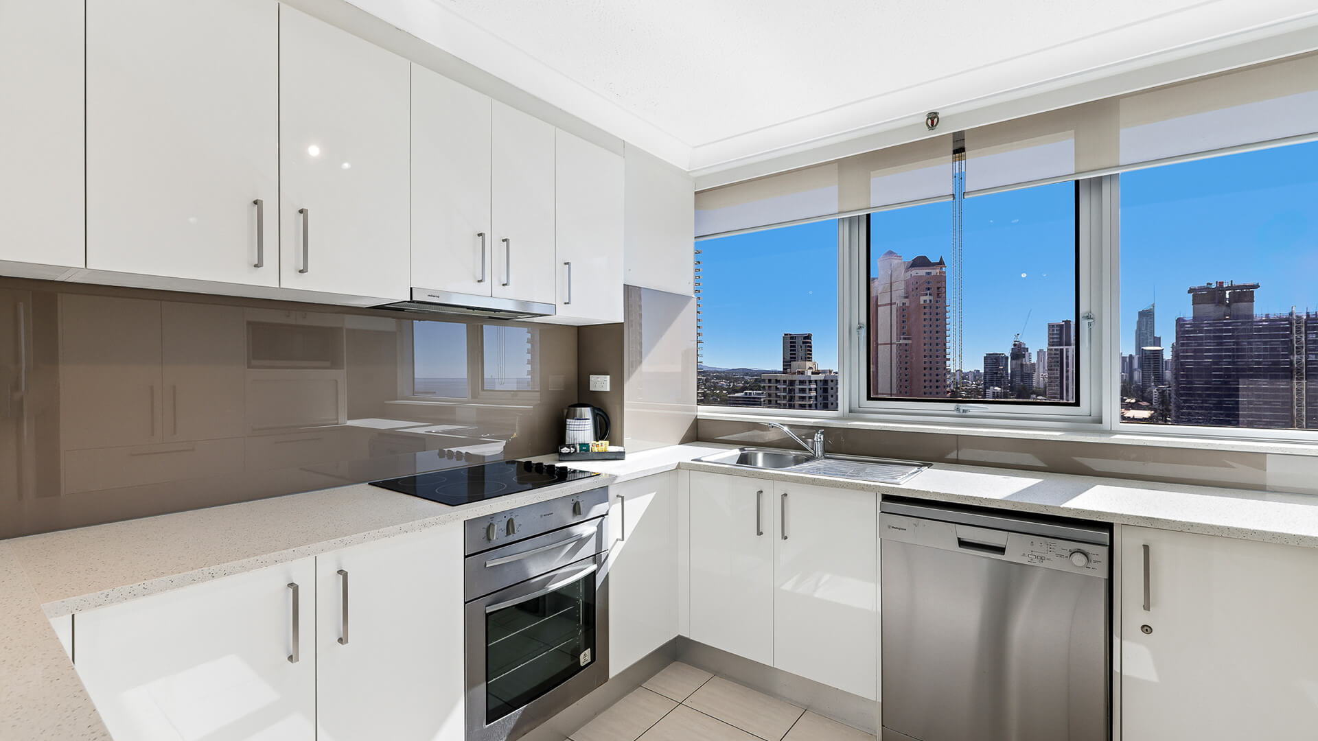 Modern kitchen in the 2 Bedroom Ocean View Apartment at ULTIQA Beach Haven with stainless steel appliances and city views.