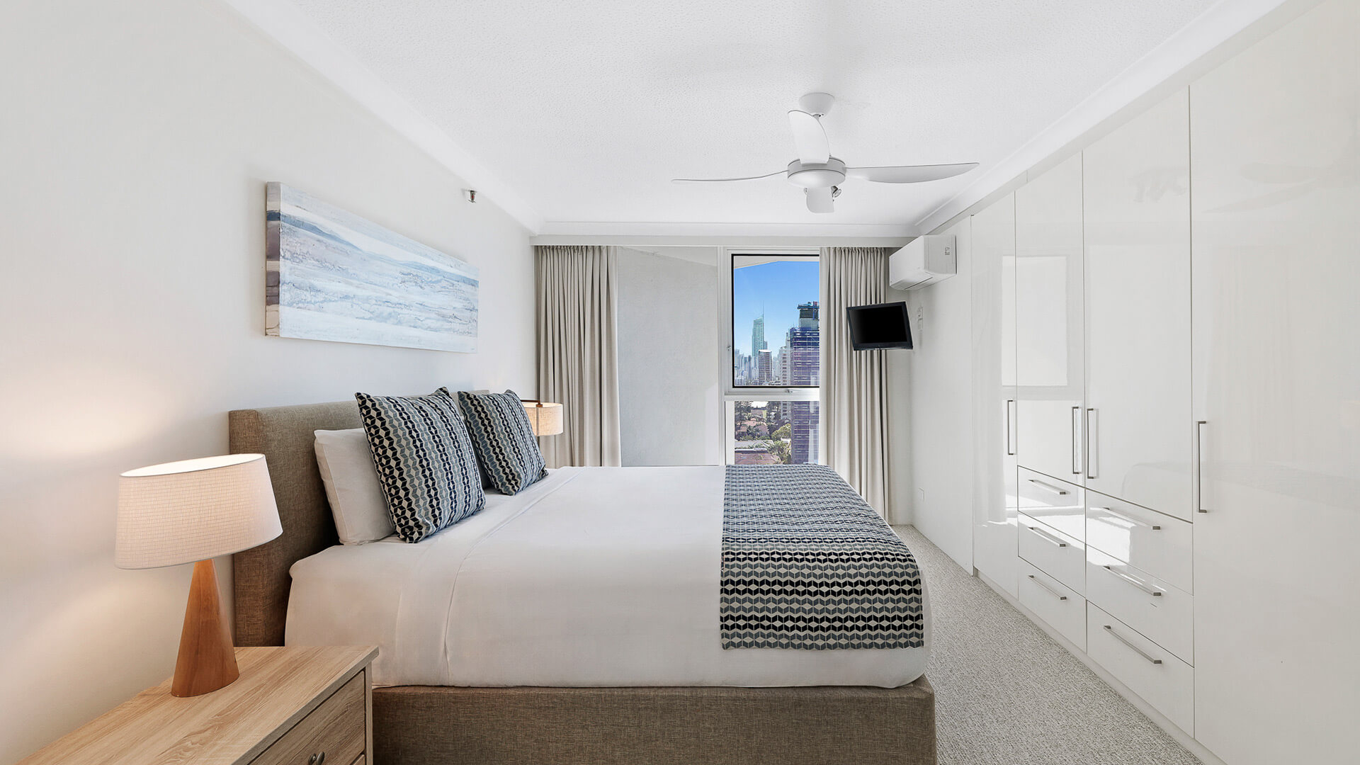Master bedroom in the 2 Bedroom Ocean View Apartment at ULTIQA Beach Haven with king bed, built-in wardrobe, and city views.