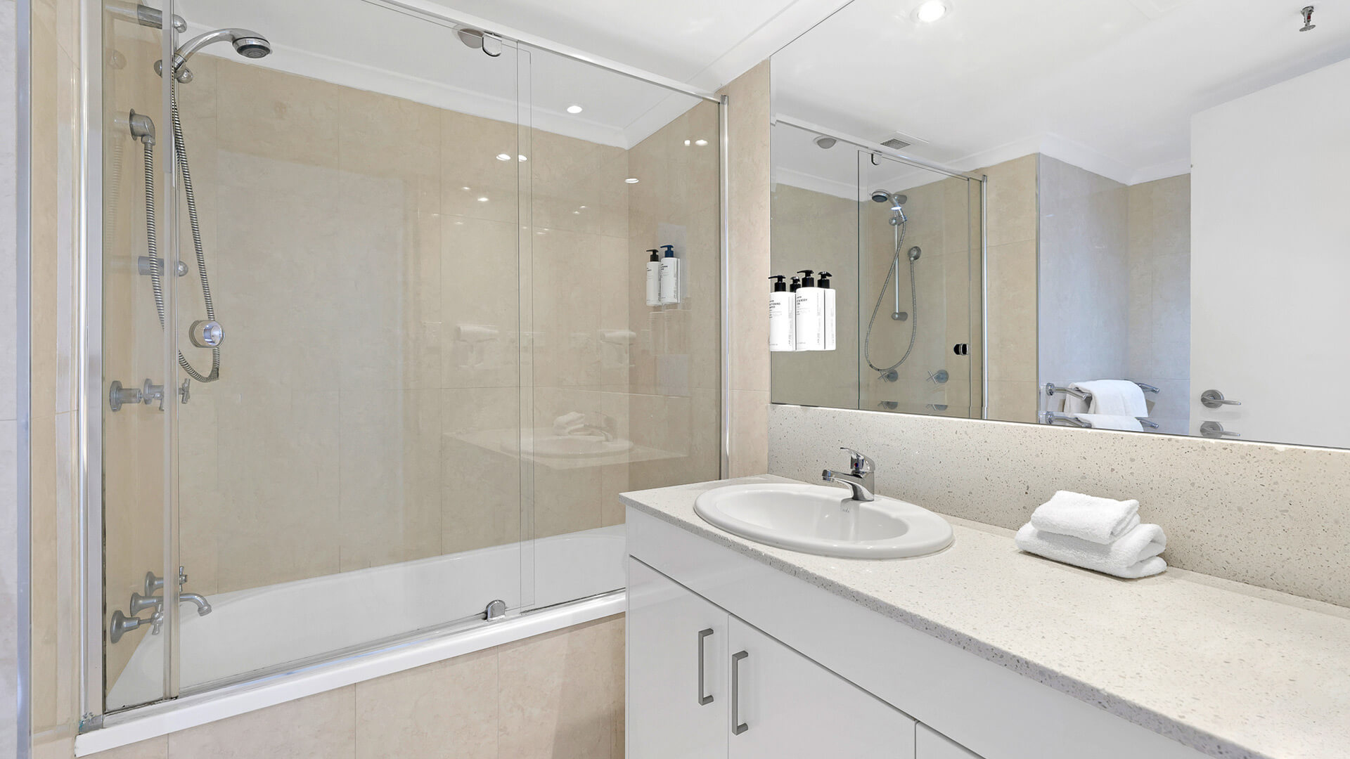 Bathroom in the 2 Bedroom Ocean View Apartment at ULTIQA Beach Haven featuring a shower over bath and stone-top vanity.