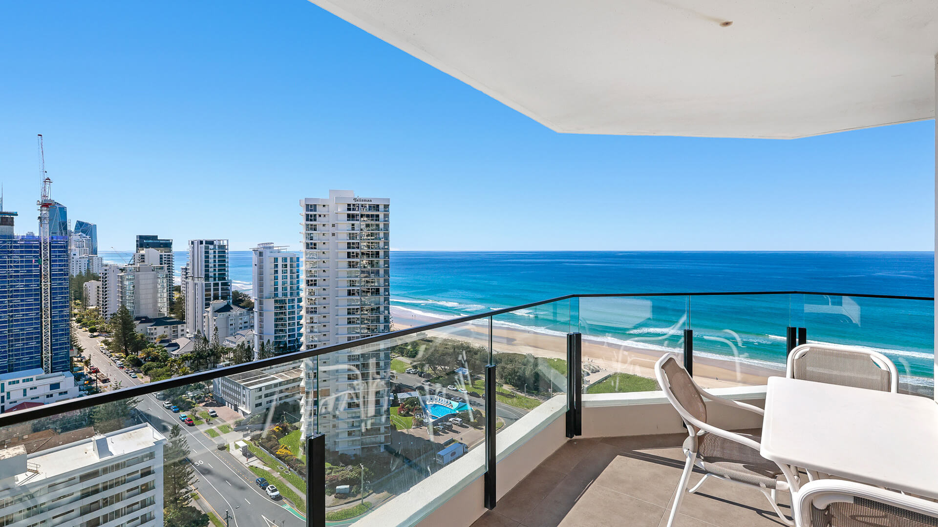 Outdoor dining setting on the balcony in the 2 Bedroom Ocean View Apartment at ULTIQA Beach Haven with panoramic views of the Gold Coast skyline and golden beachfront.