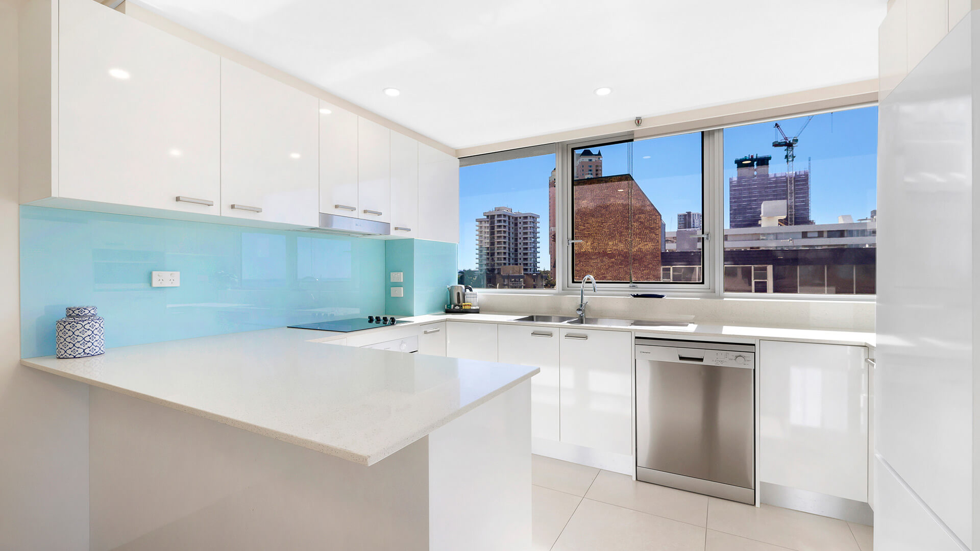 Fully equipped kitchen in the 2 Bedroom Ocean View Apartment at ULTIQA Beach Haven with modern appliances and city views.