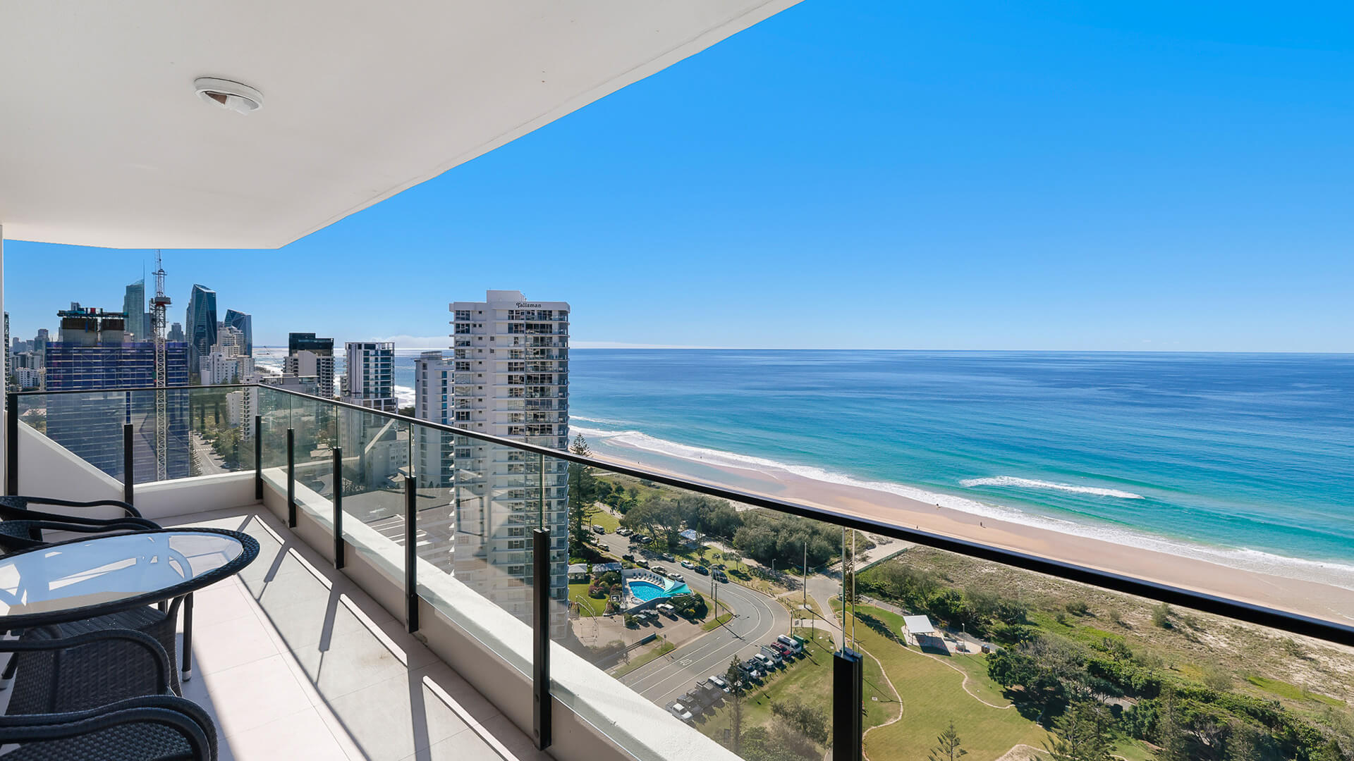 Private balcony with panoramic Gold Coast skyline and beach, complete with outdoor table and chairs.
