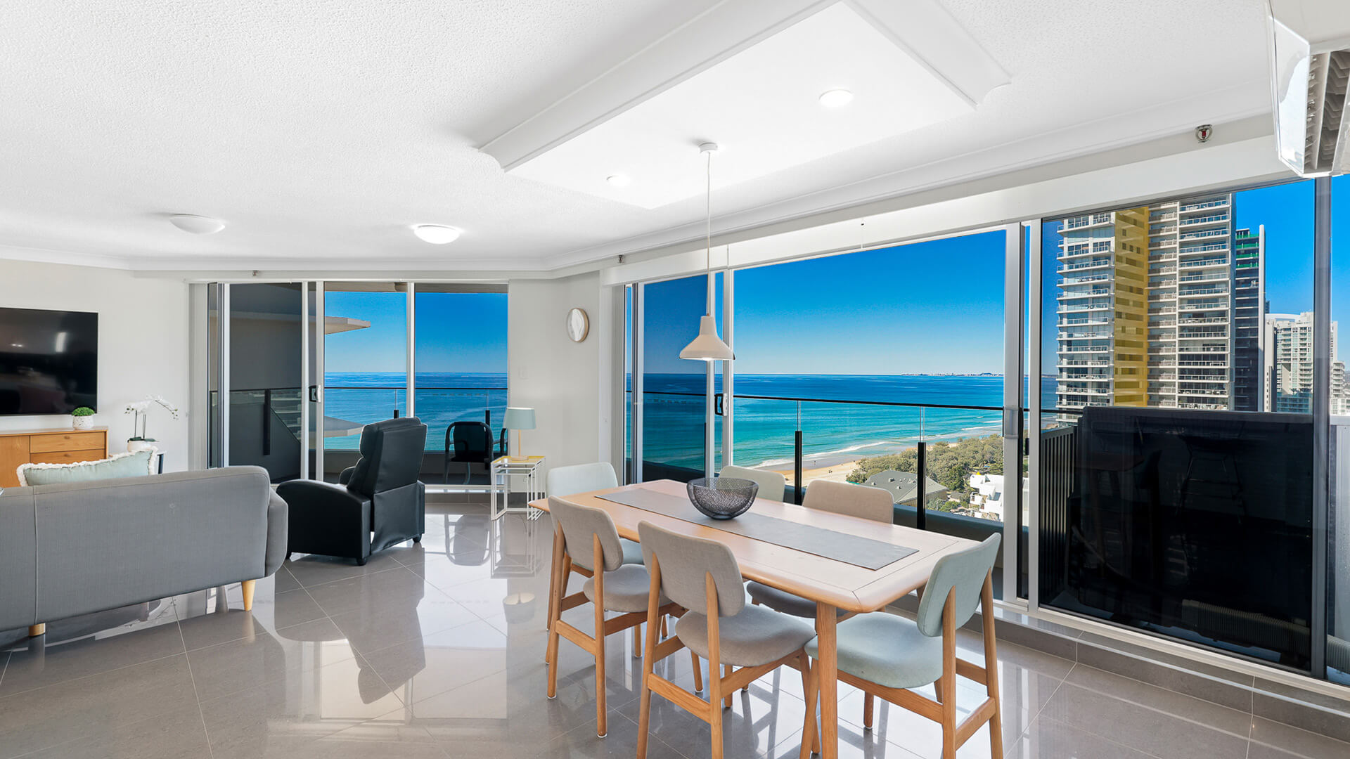 Dining area with panoramic ocean views and floor-to-ceiling windows in the Premium 2 Bedroom Ocean View Apartment at ULTIQA Beach Haven.