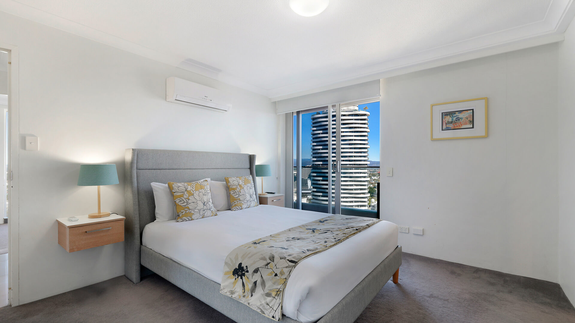 Main bedroom featuring a king bed, air-conditioning, private balcony access, and views over Broadbeach.