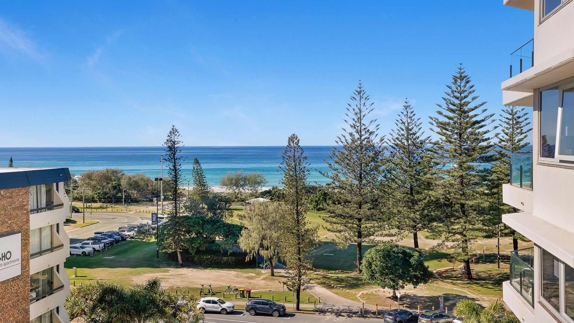 Stunning ocean view overlooking parklands, Norfolk pines, and Broadbeach beachfront with clear blue skies and turquoise waters.