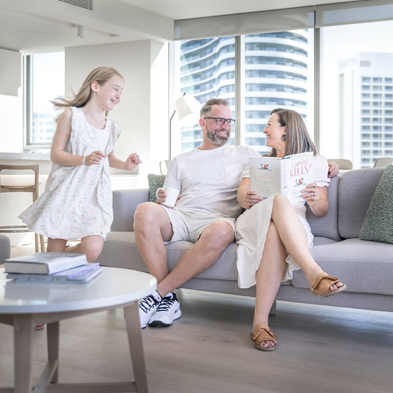 Family relaxing and spending time together in a modern apartment at ULTIQA Signature at Broadbeach.