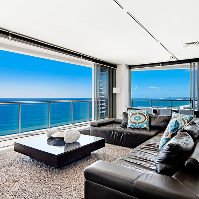 Spacious living area in the 4 Bedroom Ocean View Apartment at ULTIQA Air on Broadbeach, featuring panoramic ocean views and modern furnishings.