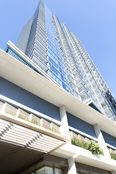 Exterior view of ULTIQA Signature at Broadbeach showcasing its modern high-rise architecture against a clear blue sky.